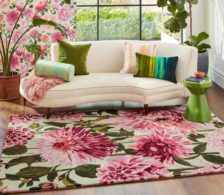 Fuchsia floral rug in a bright living room with a white sofa and colourful cushions.