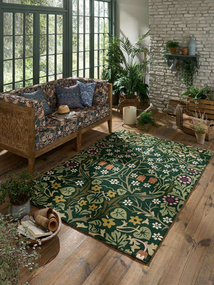 Elegant indoor space with floral patterned rug, plants, and vintage decor.
