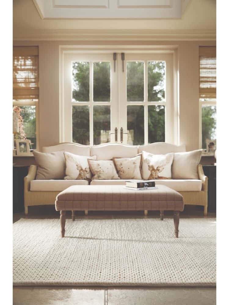 Bright living room with large windows, cream sofa, and neutral decor.