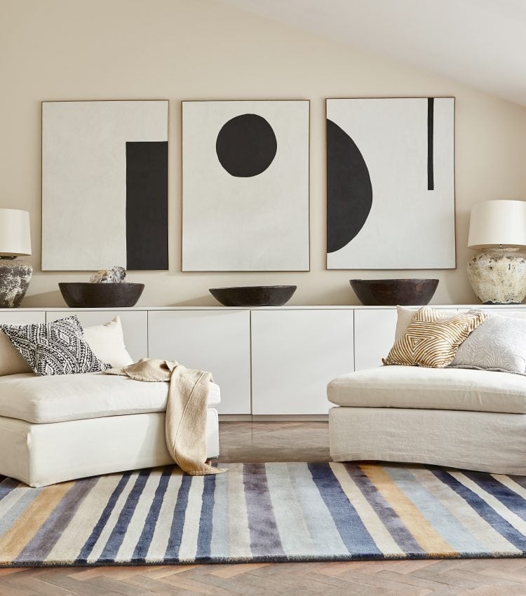 Contemporary living room with abstract black and white artwork and neutral furniture.