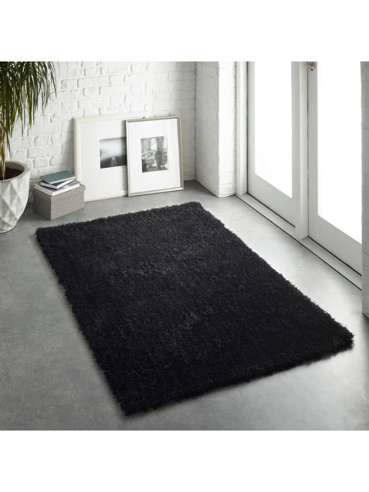 Black shaggy rug in a contemporary home setting near a glass door.