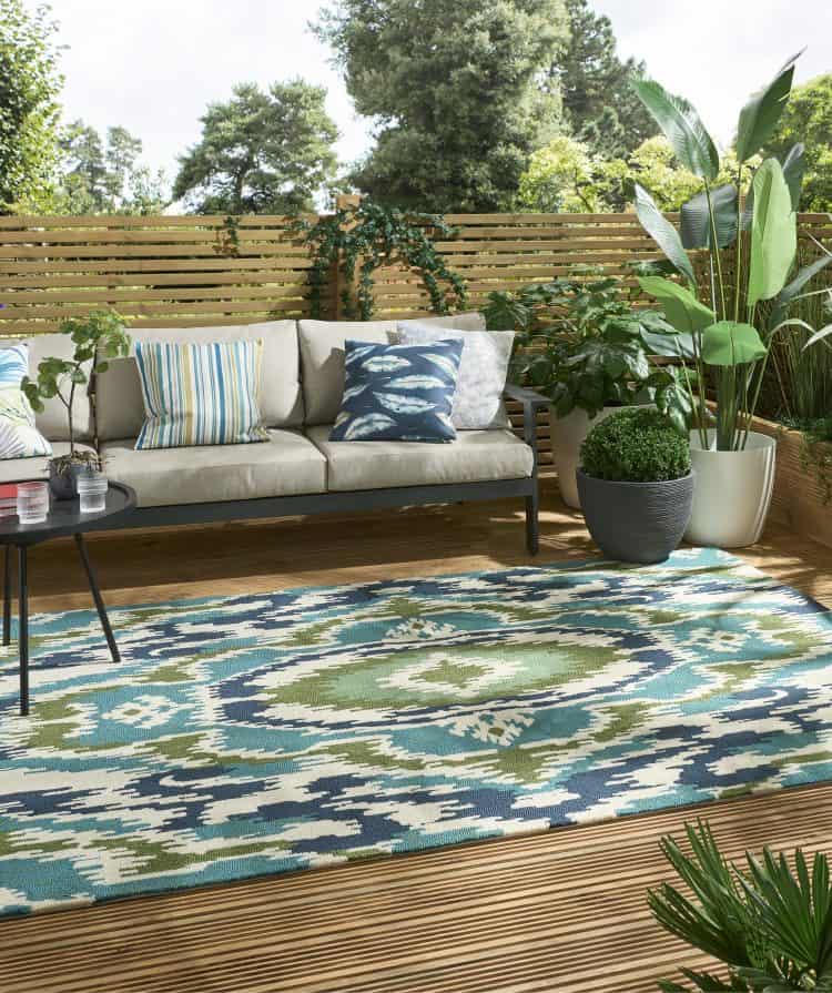 Outdoor patio with Ixora Indoor Emerald Palm rug and seating area.