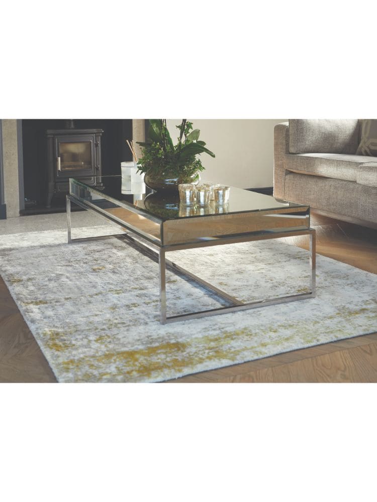 Contemporary glass and metal coffee table in a stylish living room setting.