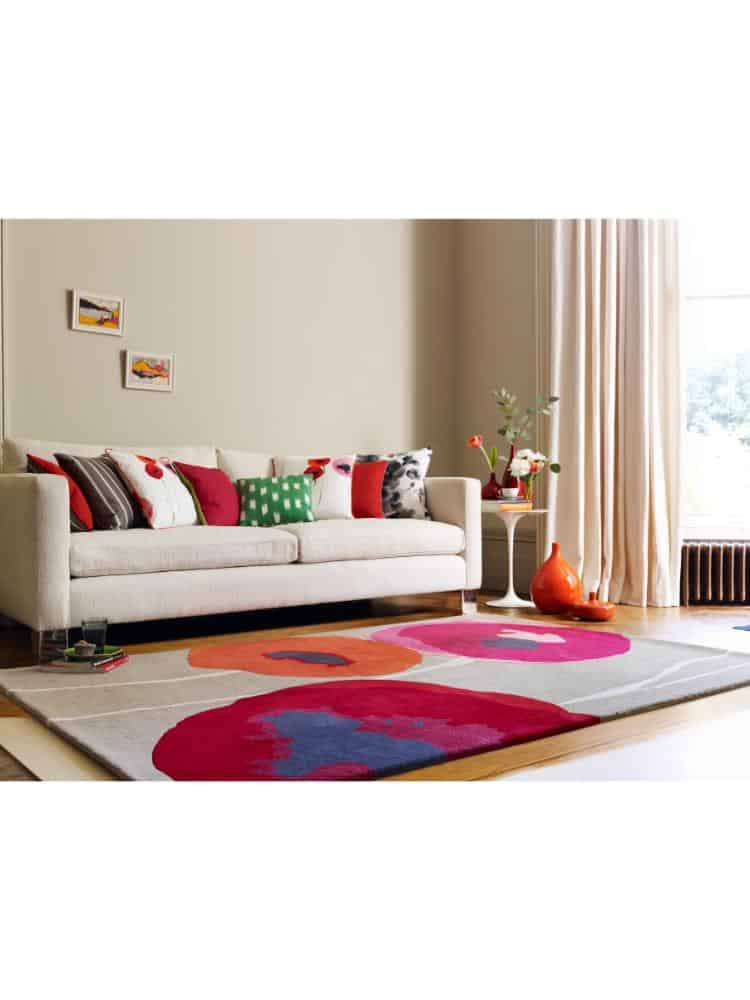 Vibrant red and orange poppies rug in modern living room setting.