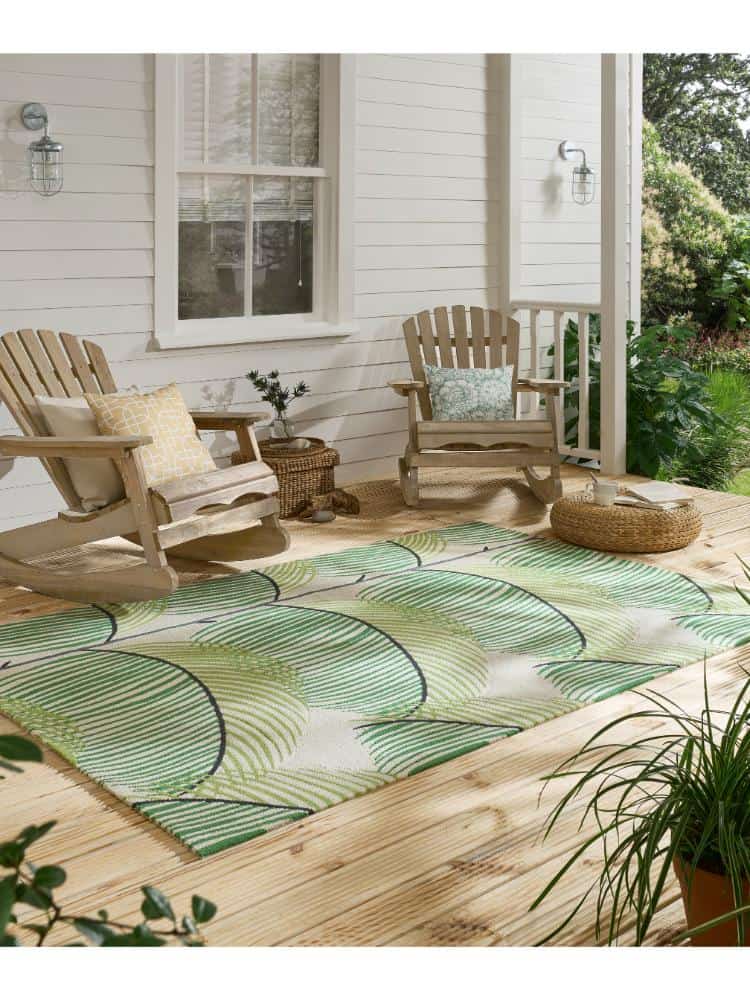 Botanical green Manila Leaf rug on porch with outdoor furniture.