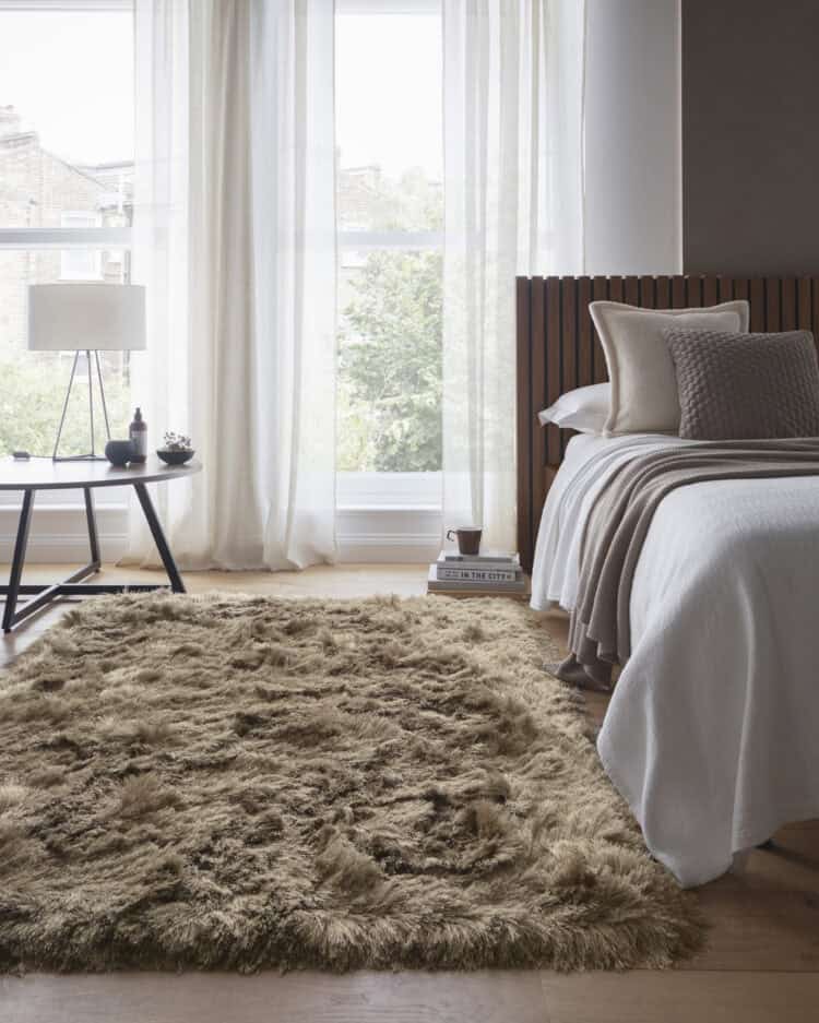 Soft beige shaggy rug in a modern bedroom with natural light.