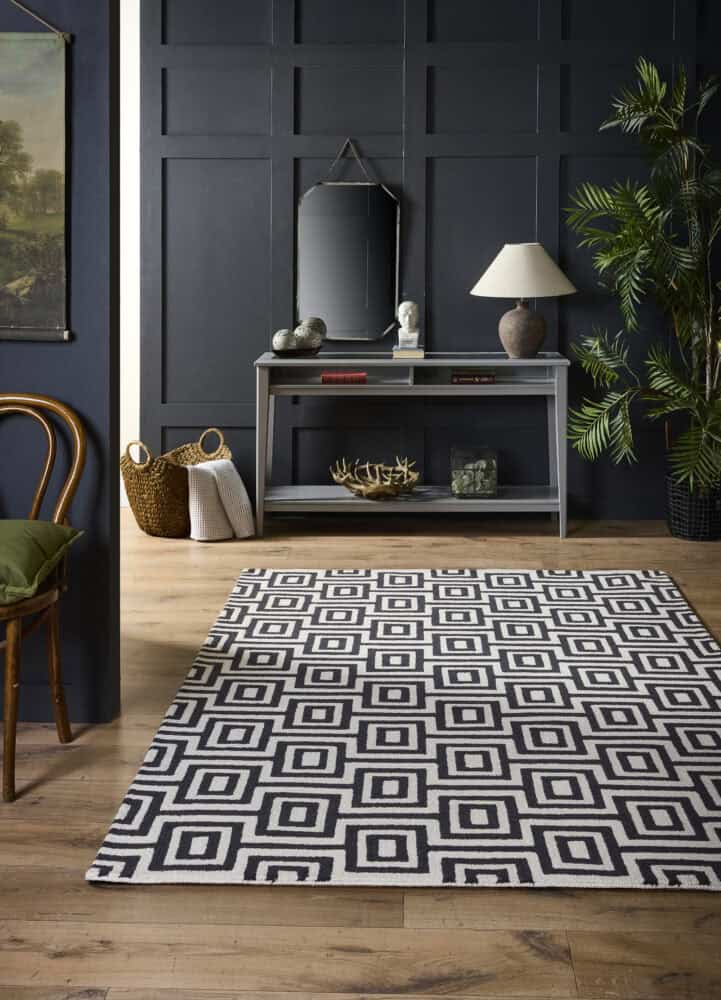 Black and white labyrinth patterned rug in modern living room.