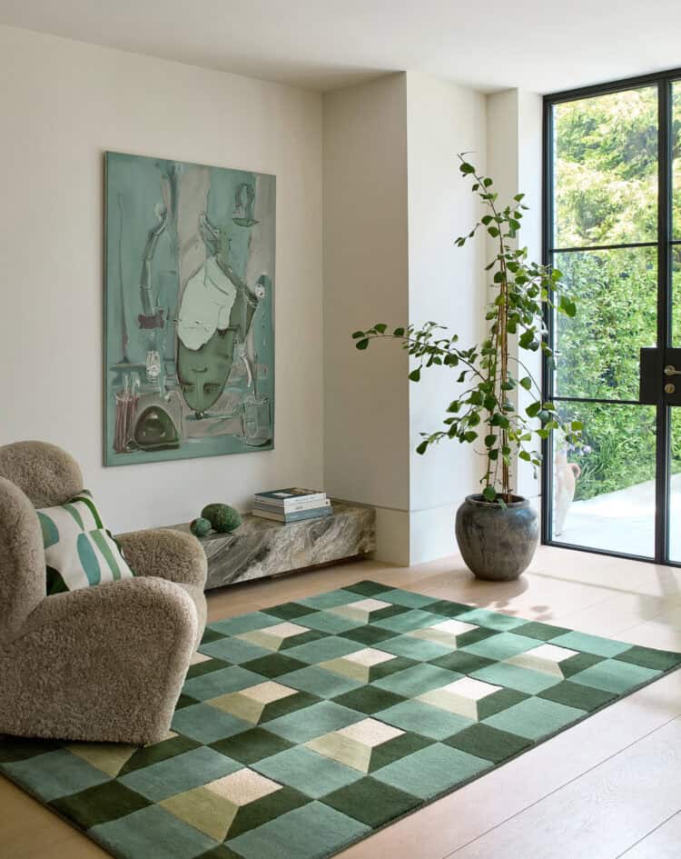 Stylish living room with a green rug, abstract art, and large window view.